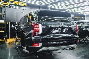 Rear view of a black SUV parked in a garage, showcasing Genuine Hyundai Parts.