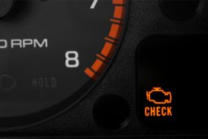 Illuminated check engine light on car dashboard, indicating potential engine problems including power loss.